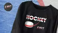 <h1>The Schott Merchandise Design</h1> We continued with designs for sweatshirts and hoodies. For hocky fans we created a hockey graphic with a hockey puck shooting out from the text, and imprinted hockey pucks with The Schott logo. Again we altered this design for various apparel and merchandise styles.